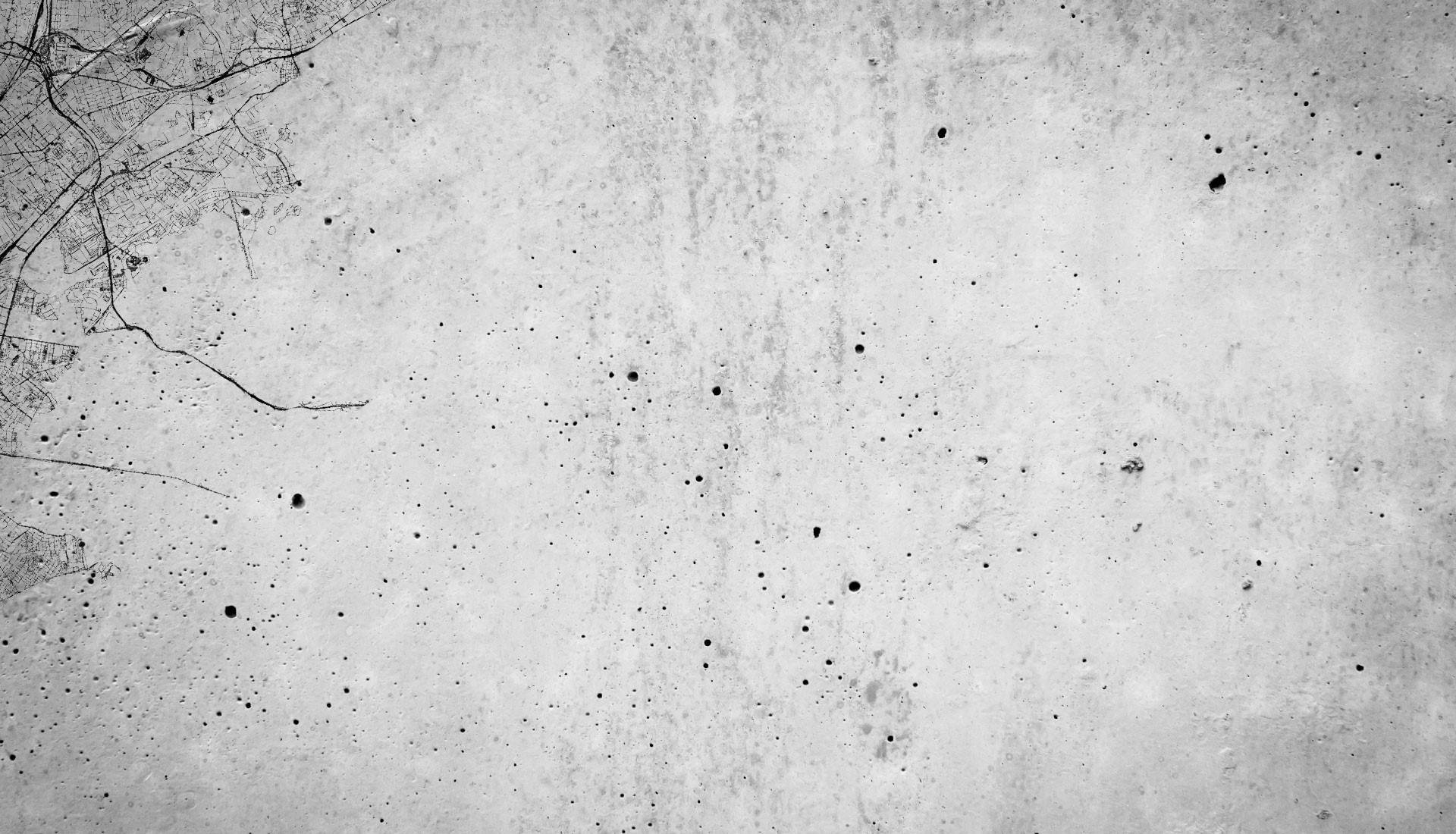 A grayscale aerial view shows a textured surface peppered with various spots and faint lines, resembling a map overlay on terrain.